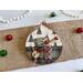 ornament with Christmas tree background, includes buttons, cranberry pips, a stamp, mini ticket strip, and a mini ornament tag.